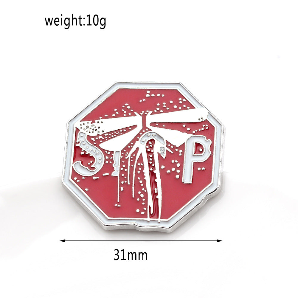 Broche de goteo de aceite con insignia M dorada