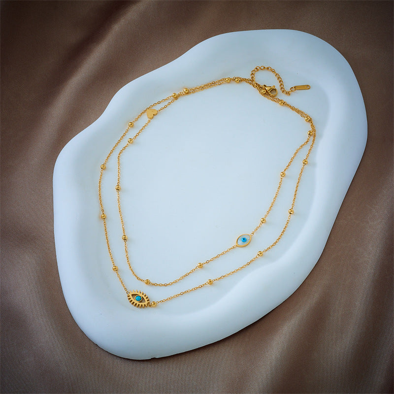 Minderheiten-Modedesign Doppellagige Mix-Kette Goldkugeln Titanstahl Tropföl Hohlblaue Augen Anhänger Halskette