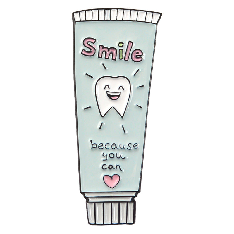Lindo broche de pasta de dientes y cepillo de dientes de dibujos animados