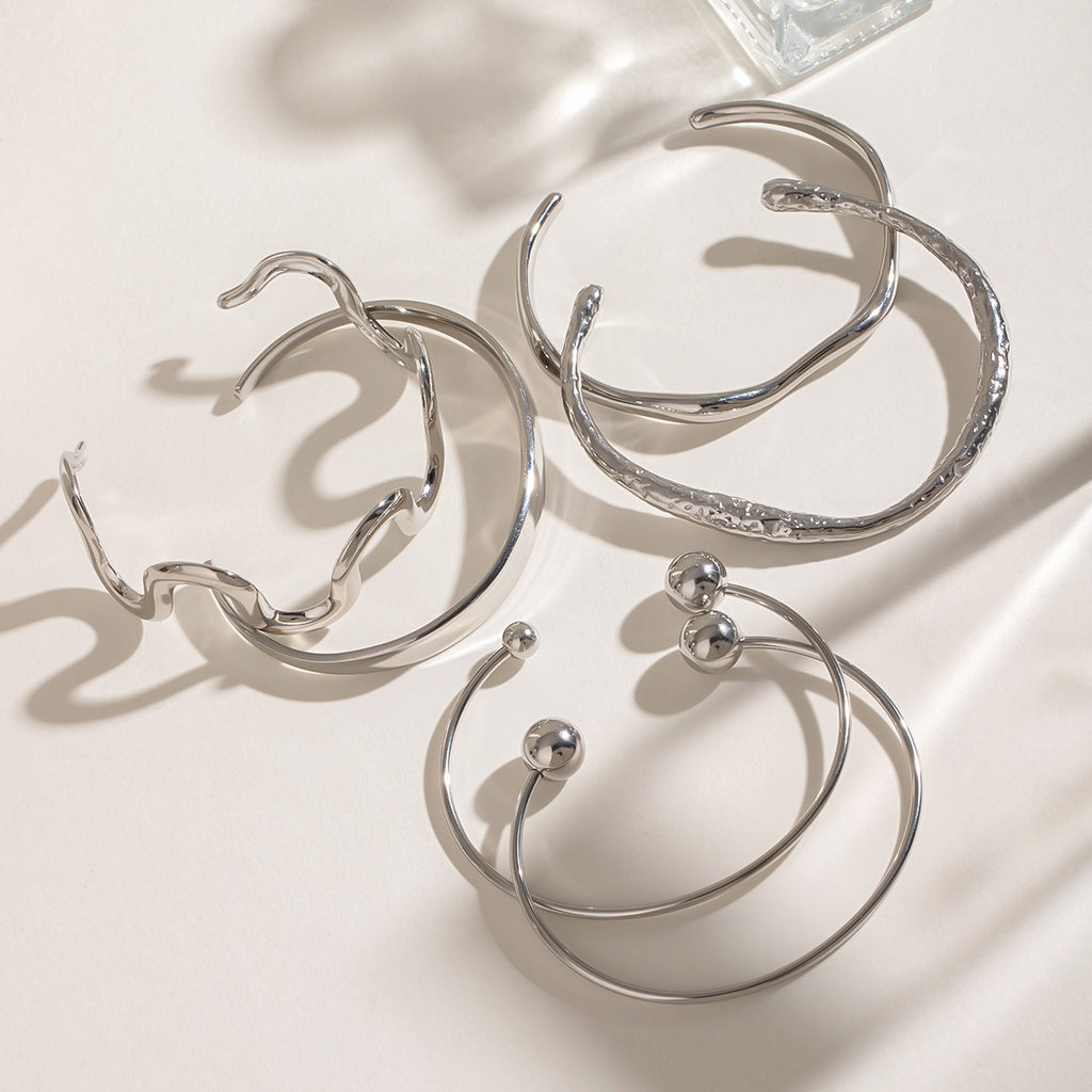 Pulsera de acero inoxidable con textura irregular esférica y diseño abierto