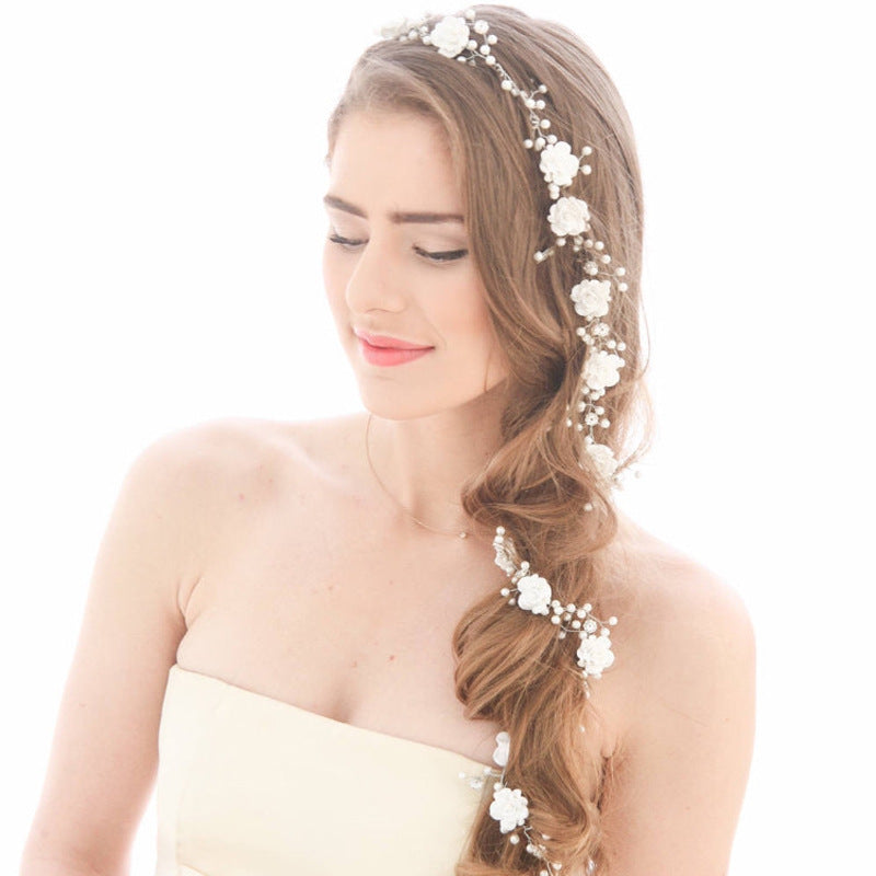 Hochzeitsfoto der Braut mit Make-up, handgemachten perlmuttweißen Blumen und langer, weicher Kettenhaarkette 1 Meter 1