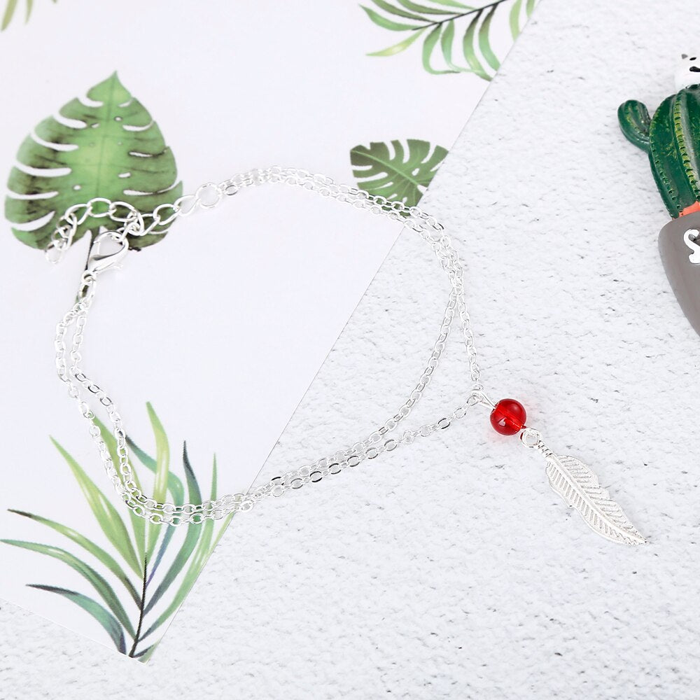 Tobillera de plumas con cuentas de cristal