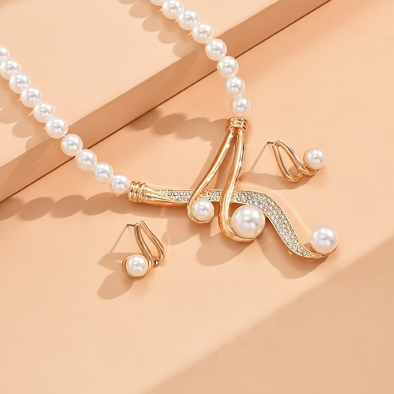 Un collar de perlas artificiales redondas y un par de pendientes geométricos de perlas artificiales redondas son modernos, elegantes y nobles, regalos perfectos para amantes y amigos.