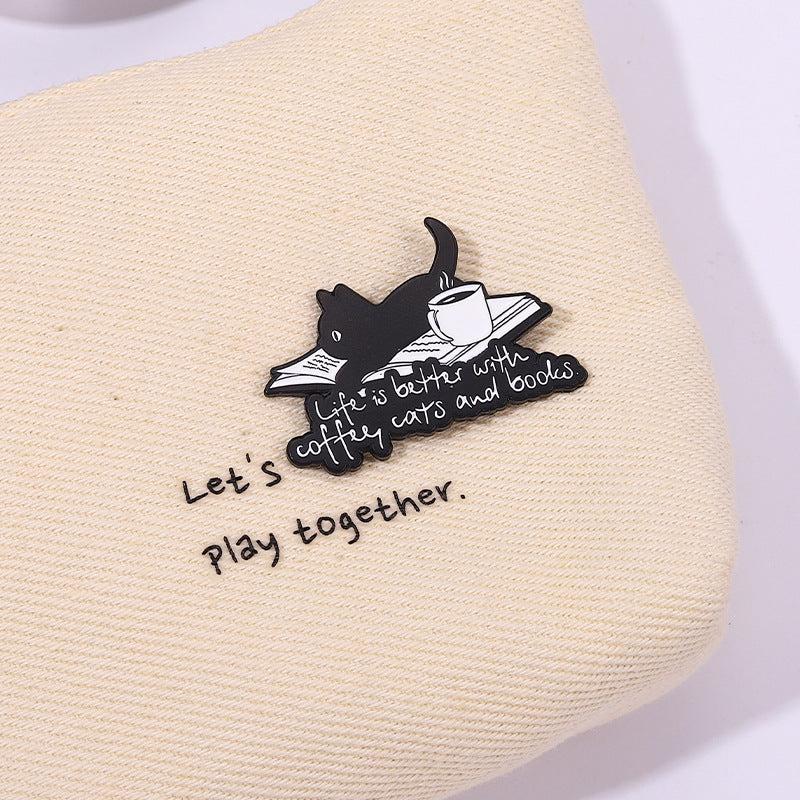 Kleine schwarze Katze Brosche Kaffee kriecht auf dem Buch