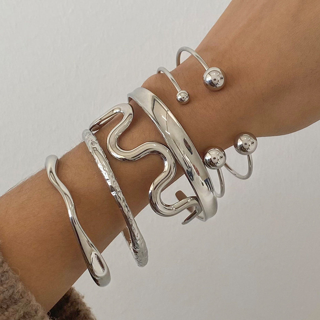 Pulsera de acero inoxidable con textura irregular esférica y diseño abierto