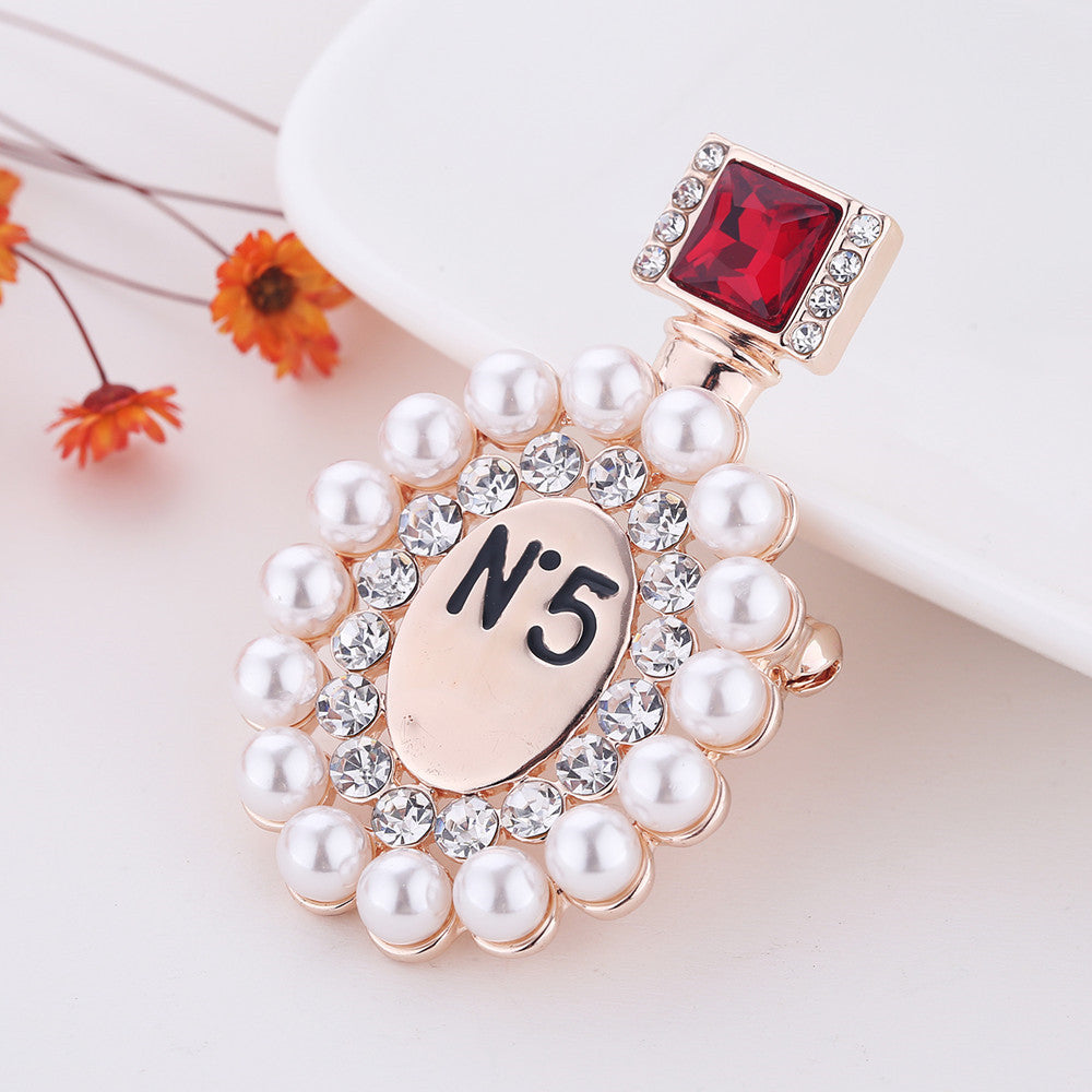 Broche de ropa de moda y elegante frasco de perfume