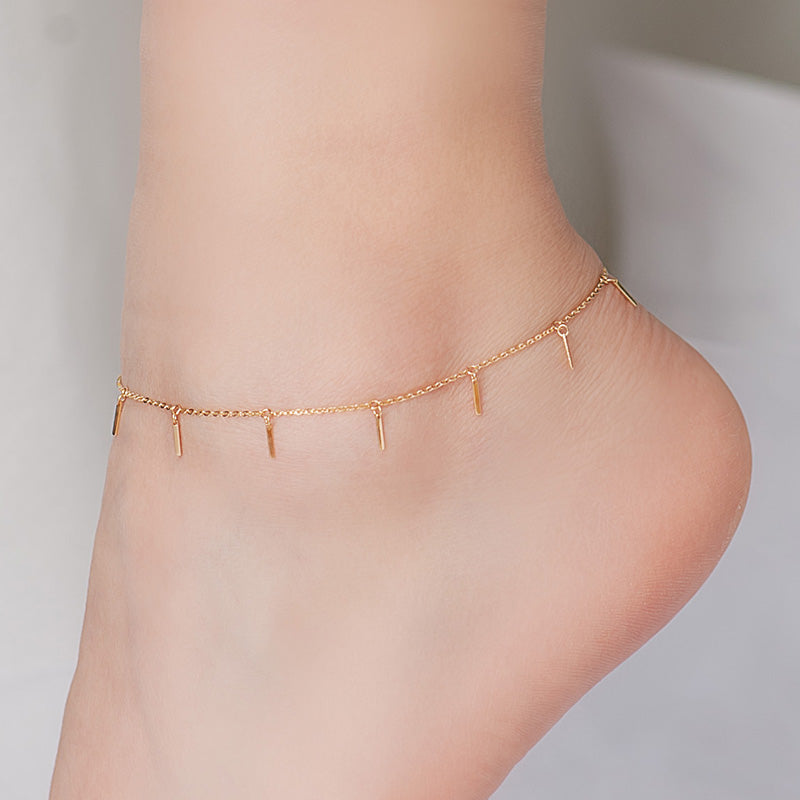 Cadena de pies sencilla e incolora con franja pequeña en color dorado