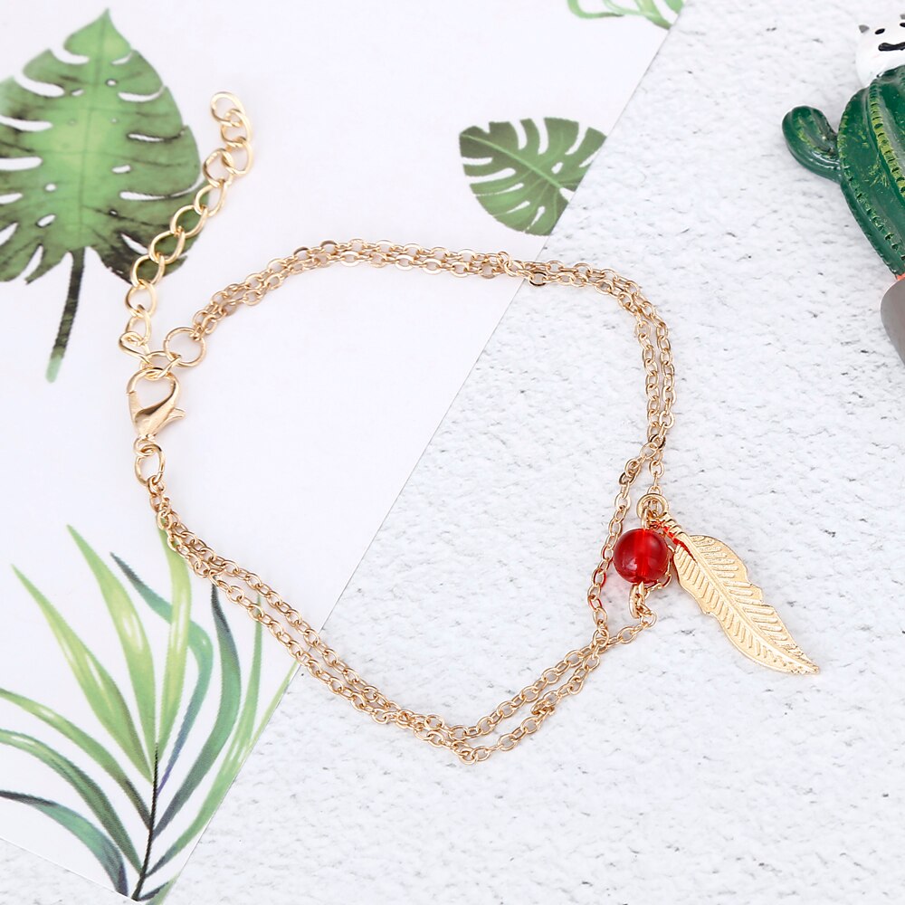 Tobillera de plumas con cuentas de cristal