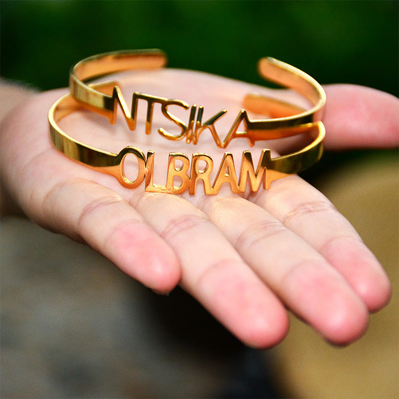 Brazalete de apertura hueca de acero de titanio con letras