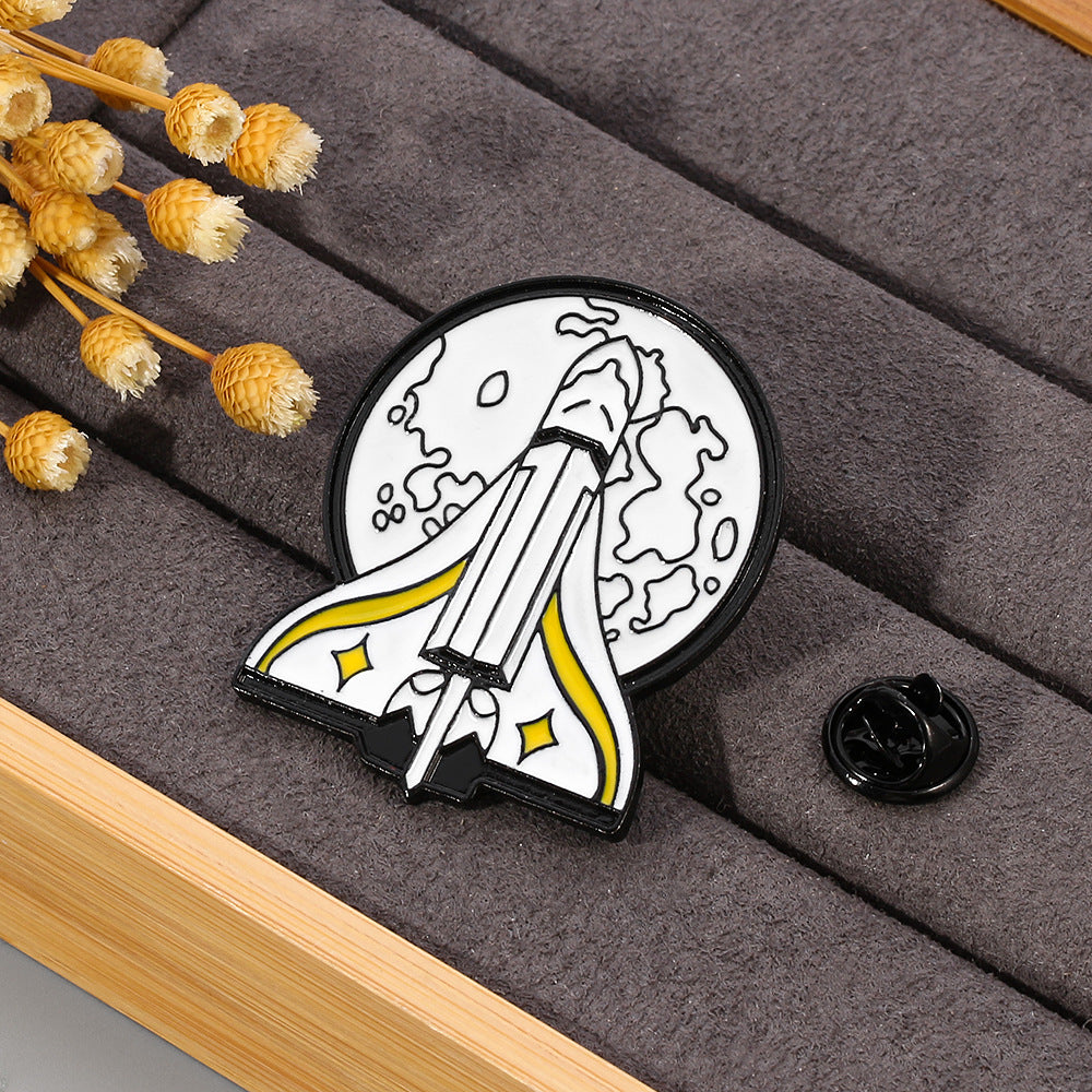 Broche de goteo de aceite con insignia M dorada