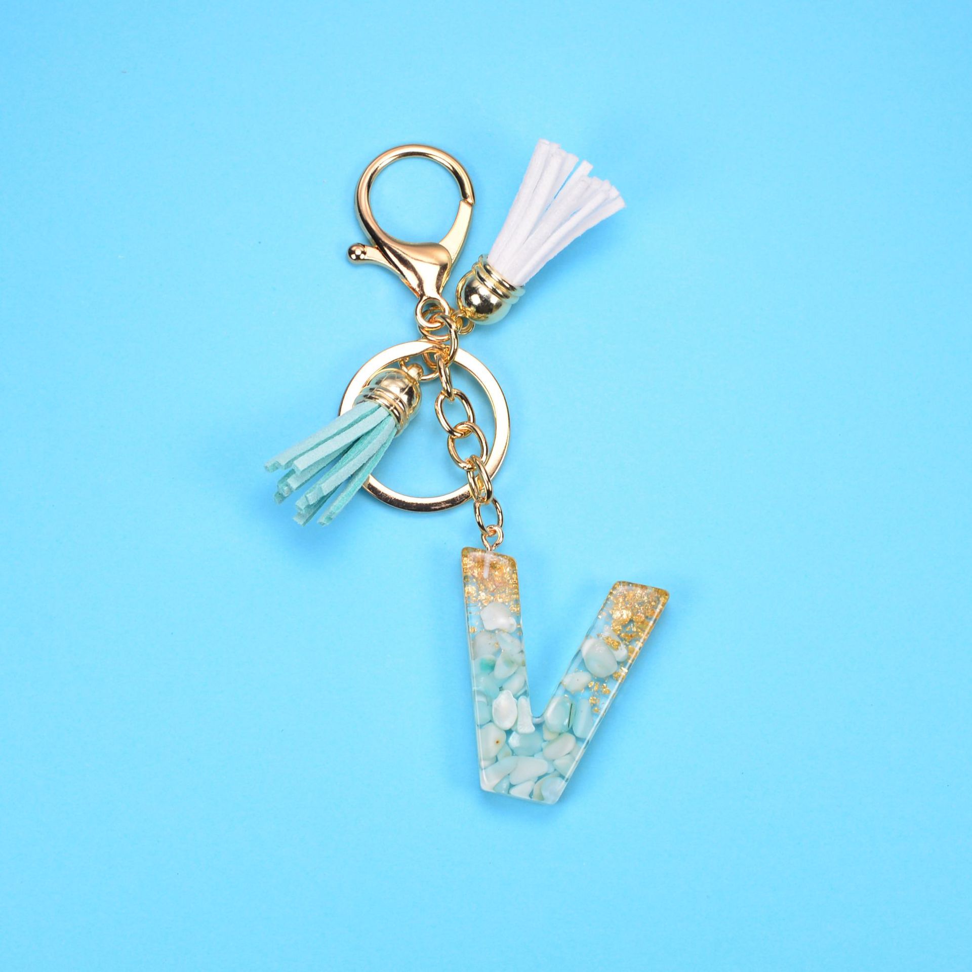 Llavero con borla y letra, piedra, lámina de oro, resina